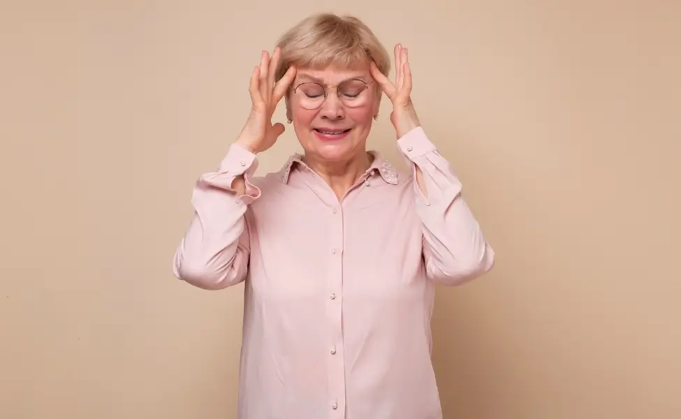 A woman in her sixties rubbing her temples