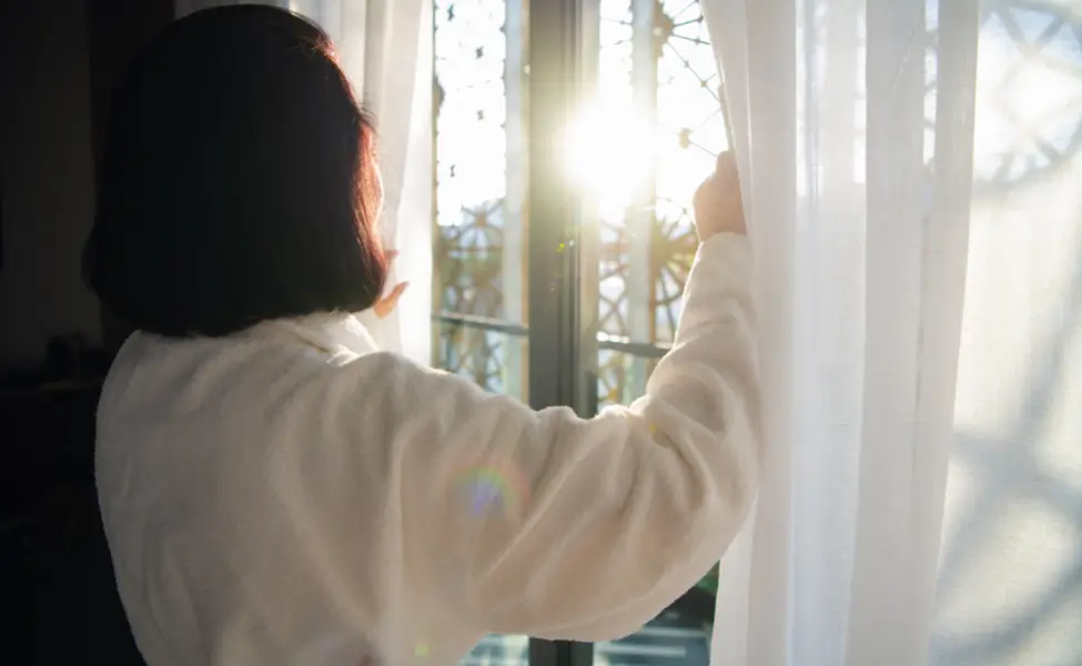 opening curtains with natural light flooding in.