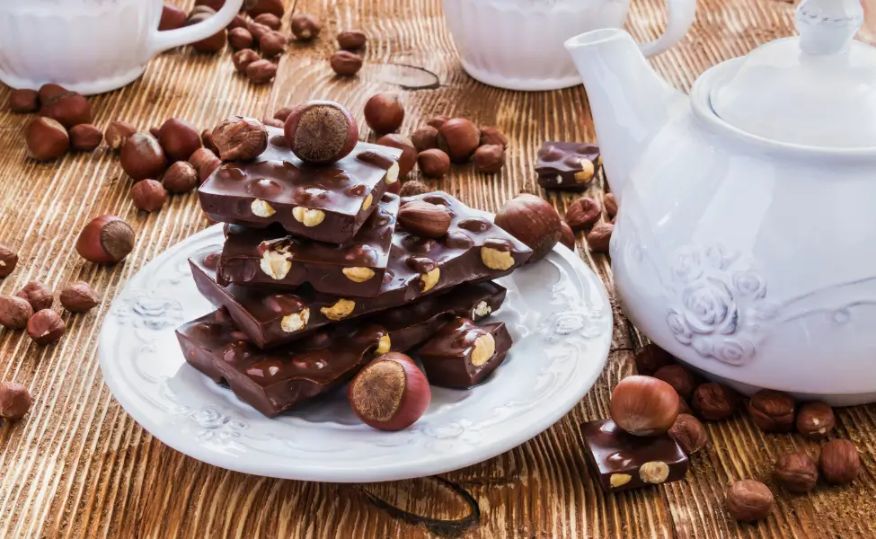 A cup of tea and a small piece of dark chocolate