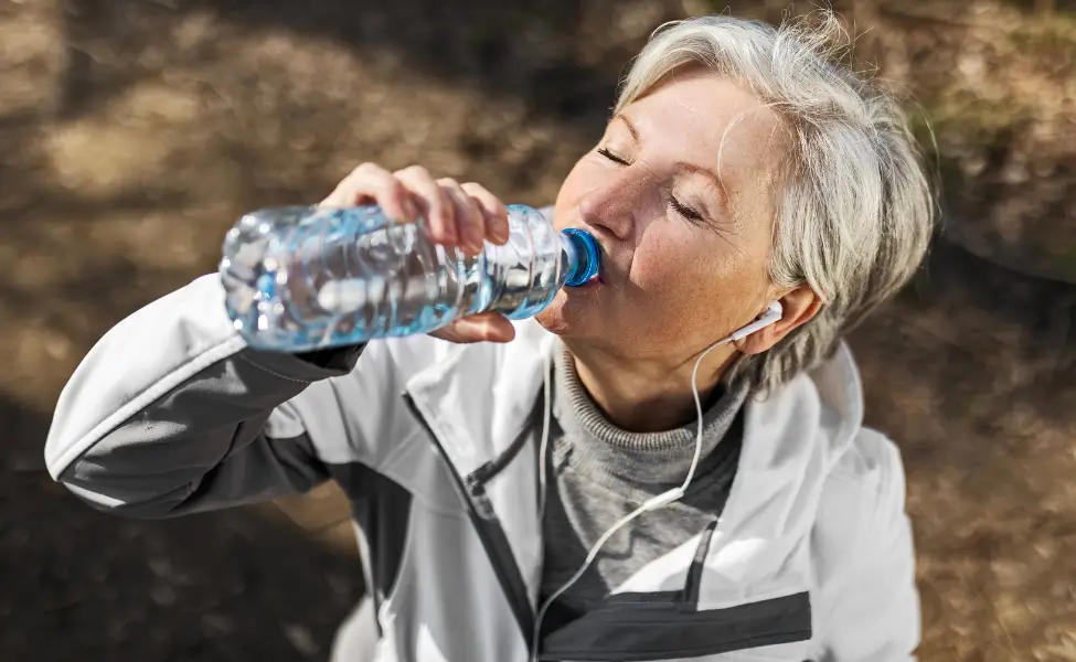 woman drinking water during hiking break