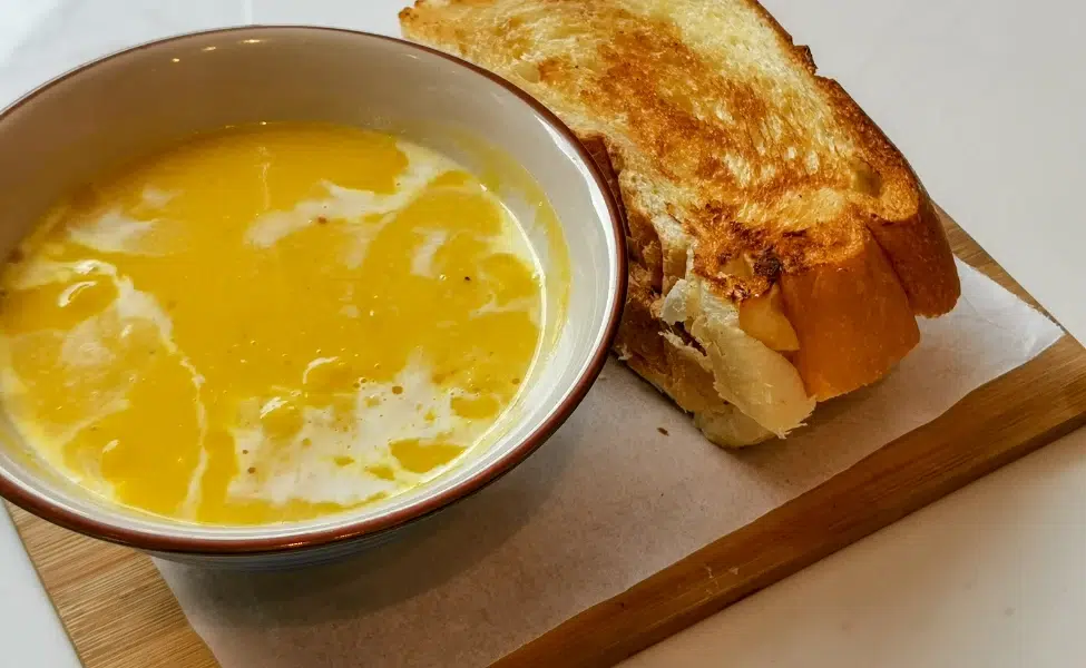 A bowl of reheated soup with a slice of toast